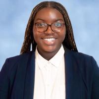 Woman in dark blue suit jacket, white shirt.